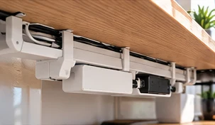 Cable management kit in white and gray under a desk