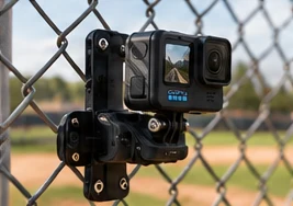Action Camera Mount in black on a chain-link fence